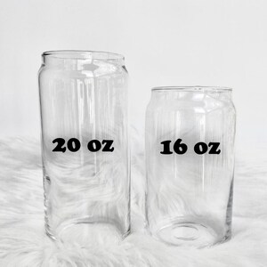 Op de afbeelding: Twee heldere glazen drinkglazen met zwarte tekst. Het grotere glas is gemarkeerd met "20 oz" en het kleinere glas met "16 oz".