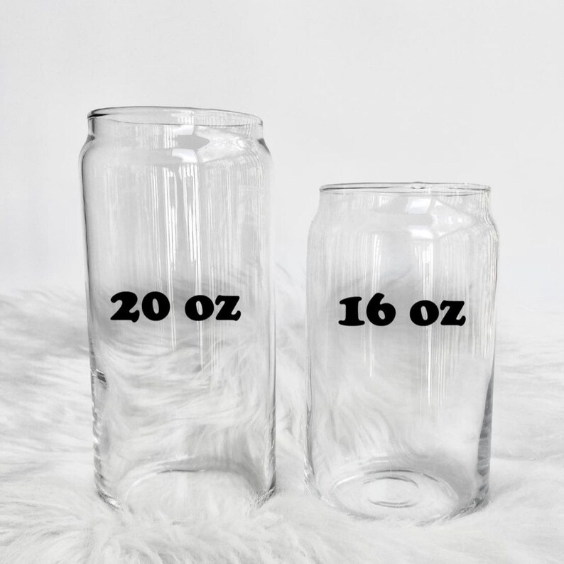 Op de afbeelding: Twee heldere glazen drinkglazen met zwarte tekst. Het grotere glas is gemarkeerd met "20 oz" en het kleinere glas met "16 oz".