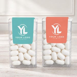 May include: Two clear rectangular plastic containers filled with white oval candies. The left container features a teal label with the white text YL YOUR LOGO, while the right container has an orange label with the same white text YL YOUR LOGO.