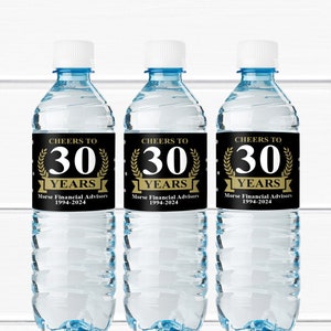 Könnte beinhalten: Drei transparente Wasserflaschen mit weißen Verschlüssen und blauen Akzenten. Jede Flasche hat ein schwarzes Etikett mit goldenem Text: "CHEERS TO 30 YEARS" und "Morse Financial Advisors 1994-2024".