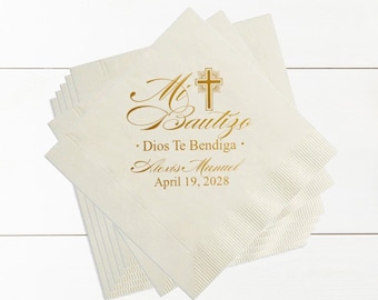 May include: A stack of white napkins with a gold cross and the text "Mi Bautizo" in cursive. The text "Dios Te Bendiga" is below the cross and the name "Alexise Manuel" and the date "April 19, 2028" are below that.