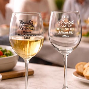 May include: Two clear wine glasses with custom text for a family reunion. One glass is filled with white wine. The text on the glasses reads "Family Reunion" and "The Smith Family Reunion Miami FL 2028".