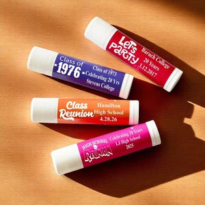 May include: Four lip balm tubes with white caps and colorful labels. One reads "Let's Party" and "Baruch College 20 Years 3.12.2017." Another says "Class of 1976" and "Class of 1973 Celebrating 20 Yrs Stevens College."