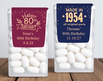 May include: Two clear plastic containers filled with white mints. One has a burgundy label that reads "Happy 80th Birthday" and "Irina's 80th Birthday 9.8.28." The other has a navy label that says "Made in 1954" and "Thomas' 80th Birthday 11.10.27."