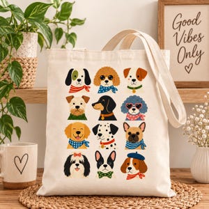 Puede incluir: Una bolsa de tela color crema con una cuadrícula de doce retratos de perros ilustrados. Cada perro lleva un accesorio diferente, incluyendo pañuelos, pajaritas, gafas de sol y sombreros en varios colores como rojo, azul y verde.