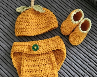 Conjunto de crochê com estampa de abóbora, incluindo gorro, botinhas e capa para fralda, para bebês de 0 a 3 meses.