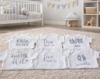 Milestone short sleeved baby onesie. White cotton vest with silver vinyl decal.