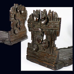 May include: A dark brown wooden bookend with a carved design of a fish swimming through reeds and flowers. The bookend is made of multiple pieces of wood that are joined together.