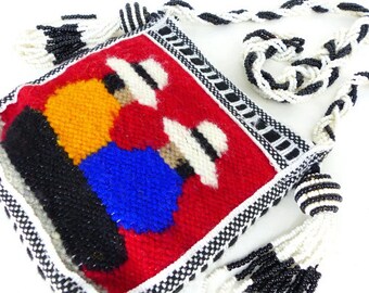 Himalayan woven wool pouch with braided black and white braided shoulder strap and tassels on each side. 2 ladies Front & back view