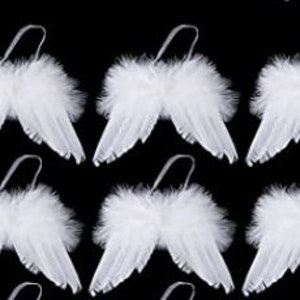 May include: A repeating pattern of small, white angel wings with feathery accents and a silver loop for hanging. The wings are set against a black background, creating a high-contrast visual.