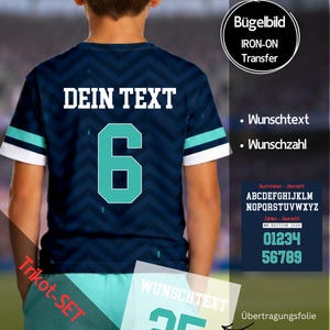 Könnte beinhalten: Ein dunkelblaues Kurzarmtrikot mit Chevron-Muster, das auf der Rückseite den weißen Text DEIN TEXT und die große türkisfarbene Nummer 6 zeigt. Die Ärmel haben weiße und türkisfarbene Streifen. Enthält eine Bügelfolie für individuellen Text und Zahlen.