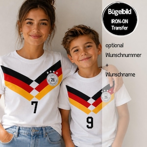 Könnte beinhalten: Zwei weiße T-Shirts mit einem schwarzen, roten und goldenen Chevron-Muster auf der Brust, einem kreisförmigen Emblem mit der Zahl 26 sowie den aufgedruckten Zahlen 7 und 9. Der Text umfasst Bügelbild, IRON-ON Transfer, optional, Wunschnummer und Wunschname.