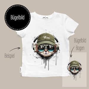 Könnte beinhalten: Weißes T-Shirt mit einer Katze, die Sonnenbrille, eine grüne Kappe mit dem Text "IF YOU ONLY KNEW" und Kopfhörer trägt. Die Katzen-Grafik hat einen Aquarell-Effekt mit schwarzen Farbspritzern.