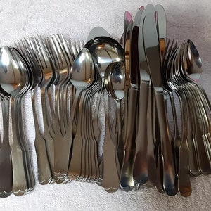May include: A set of silverware, including forks, spoons, and knives, arranged in a neat pile. The silverware is made of polished stainless steel and has a classic design.
