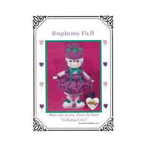 May include: A crochet doll named "Raspberry Fluff" is featured in this image. The doll is dressed in a purple dress, hat, and shoes, and is holding a small purse. The text "Brought to you directly from Lollipop Lane" is also visible.