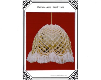 Puede incluir: Una lámpara de macramé color crema con flecos en la parte inferior. La lámpara tiene un patrón geométrico y está suspendida de un solo cable. El texto "Macrame Lamp - Savoir-Faire" se muestra en la parte superior de la imagen.