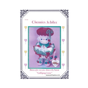 May include: A framed image featuring a doll named "Cherries Jubilee." The doll is dressed in a red and white crocheted outfit, including a hat, collar, and shoes. The image includes text that reads "Brought to you directly from Lollipop Lane."