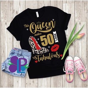 May include: Black t-shirt with gold text that reads "This Queen makes 50 look fabulous". The text is surrounded by a crown, a leopard print high heel shoe, and red lips.