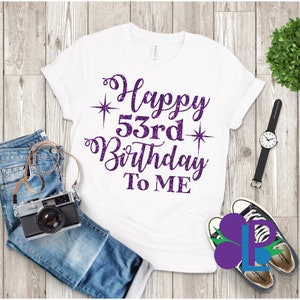 May include: White t-shirt with purple glitter text that says "Happy 53rd Birthday To Me".