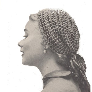 May include: A vintage black and white photograph of a woman wearing a crocheted head covering. The head covering is a net-like design, and the woman is wearing a pearl earring. The woman is facing left.