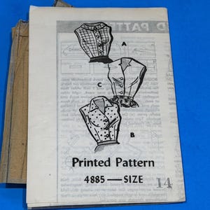 May include: A vintage printed sewing pattern, featuring illustrations of three blouse designs. The pattern is labeled "Printed Pattern 4885 - SIZE 14" and includes detailed diagrams and instructions. The background is a solid blue.