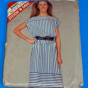 Könnte beinhalten: Ein Schnittmusterumschlag mit der Aufschrift 8490 Size B (16-18-20) Stitch 'N Save. Die Vorderseite zeigt ein Foto eines Kleides mit einem blau-weißen vertikalen Streifenmuster auf dem Oberteil und Rock sowie horizontalen Streifen am Saum.
