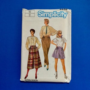 以下が含まれることがあります： 青い背景に、ヴィンテージのSimplicityの裁縫パターンパッケージ。 パッケージには、ブラウスとキュロット、ブラウスとズボン、Tシャツとスカートの3つの異なる衣装のイラストが描かれています。 パッケージには番号10とEur 38と記載されています。