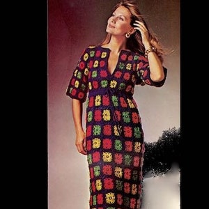 Può includere: Un abito all'uncinetto colorato, al ginocchio, con scollo a V e maniche corte. L'abito presenta un design patchwork con quadrati rossi, gialli, verdi e neri. La modella indossa scarpe abbinate.