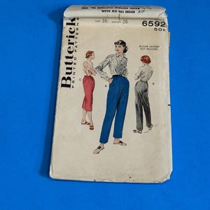 May include: Vintage Butterick printed pattern for a blouse and pants. The pattern features illustrations of the designs, with measurements of hip 35 inches and waist 26 inches. The pattern is labeled "6592" and includes the text "Blouse pattern not included."