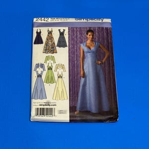 May include: Simplicity sewing pattern 2442 featuring various dress designs. The cover shows a woman in a light blue gown. The pattern includes sizes H5: 6, 8, 10, 12, 14 and EUR 32-40, FR 34-42. The Simplicity logo is at the top.