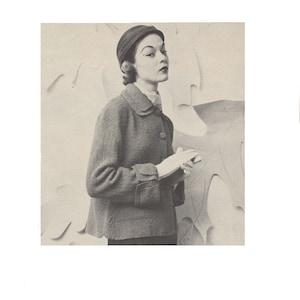 May include: A vintage fashion photograph featuring a woman in a dark, textured jacket with a rounded collar and button closure. She wears a matching hat and gloves. The background is a neutral tone with abstract shapes.