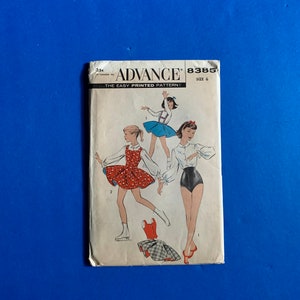 May include: Vintage Advance sewing pattern, featuring illustrations of figure skating outfits. The pattern cover shows three figures in different outfits, including a red polka-dot dress and a blue tutu. The text "ADVANCE" is prominently displayed.