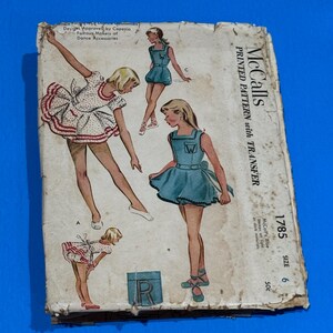 May include: Vintage McCall's printed sewing pattern for dance costumes. The cover features illustrations of young girls in ballet outfits. The pattern includes a transfer and is size 6. The cover is aged with wear and tear.