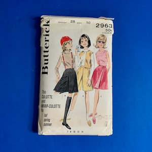 May include: A vintage Butterick sewing pattern envelope featuring illustrations of culottes and wrap-culottes. The cover shows three figures in different outfits, with text indicating sizes and seasons. The envelope is white with black text and illustrations.