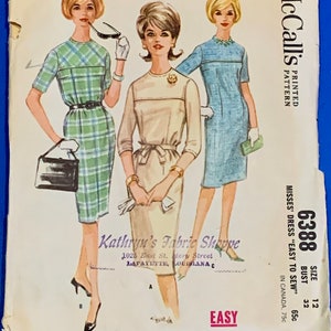 Puede incluir: Sobre de patr&oacute;n de costura McCall's vintage con ilustraciones de tres vestidos. El sobre muestra el n&uacute;mero de patr&oacute;n 6388, la talla 12 y el texto "Easy to Sew". Los vestidos son de cuadros verdes, beige y azul claro.