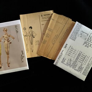 May include: Vintage McCall's sewing patterns for dresses, featuring illustrations of the finished garments. The patterns are labeled with the number 5279 and include instructions and cutting layouts. The patterns are in various conditions.
