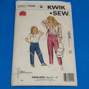 May include: A Kwik Sew pattern envelope 1506 for sizes 4-5-6-7. The front shows illustrations of two outfits: a white top with blue pants and a striped shirt with a vest and pink pants. The text includes the brand name, pattern number, and address.