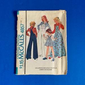 May include: A vintage McCall's 4857 sewing pattern for children's and girls' overalls, jumpers, and blouses. The pattern cover shows illustrations of the garments on young models. The pattern is size 5.