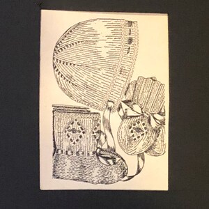 May include: A detailed illustration of antique baby garments: a bonnet, booties, and a small bag. The bonnet features a lace trim and button accents. The booties are tied with ribbons. The bag has a diamond pattern.
