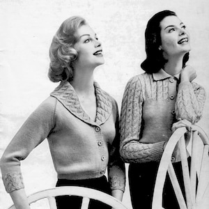 Puede incluir: Dos mujeres con cárdigans de punto de color claro con detalles de punto trenzado en el cuello y las mangas. Los cárdigans tienen cierres de botones y se combinan con pantalones oscuros. Las mujeres se apoyan en sillas blancas.