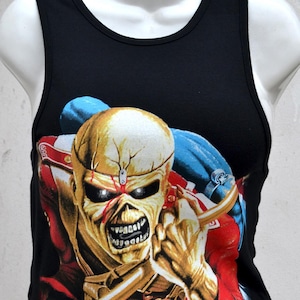 Könnte beinhalten: Schwarzes Tanktop mit einer Grafik einer skelettartigen Figur mit goldenem Kopf, roten Akzenten und blauen Details. Das Design ist eine lebendige Illustration mit einem bedrohlichen Ausdruck.