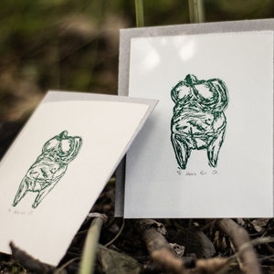Può includere: Due stampe incorniciate di un disegno a linea verde di una figura femminile. La stampa a destra ha il testo "#6  Anika  Fett  Ch."