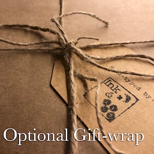 May include: A brown paper package tied with twine and a brown paper tag. The tag has a black stamp that says "Ink & Co. Hand-typed by..." and the text "Optional Gift-wrap" is printed below the package.
