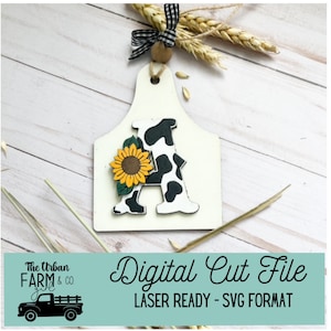Può includere: Un ritaglio di legno bianco a forma di tagliere con una lettera A a stampa di mucca in bianco e nero e un girasole giallo in cima. Il testo "Digital Cut File" e "LASER READY - SVG FORMAT" è sotto l'immagine.