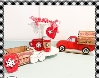 May include: Red wooden truck with a wooden crate that says "Old Fashioned Hot Cocoa".  There are also red and white mugs, marshmallows, and a white tiered stand with red and white decorations.