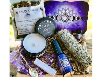 May include: A gift box filled with items for a moon ritual. The box contains a candle, a tea bag, a smudge stick, a bottle of essential oil, a selenite wand, and a card with a moon phase design. The box is decorated with a purple and blue starry sky design.
