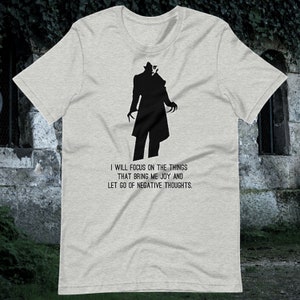 May include: A gray t-shirt with a black silhouette of a man with a quote: "I will focus on the things that bring me joy and let go of negative thoughts."