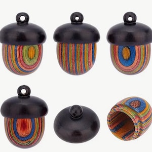 May include: Six wooden acorn-shaped ornaments with colorful striped and circular patterns. The ornaments have a black top and a colorful bottom. One ornament is open to show the inside.