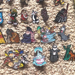 May include: A collection of enamel pins featuring various cartoon characters, including Mickey Mouse, Winnie the Pooh, and the Grinch. The pins are colorful and detailed, and they would make a great addition to any fan's collection.