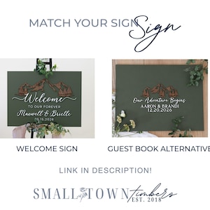 May include: Two rectangular olive green signs featuring a 3D wooden mountain range cutout. The left sign displays 'Welcome TO OUR FOREVER Maxwell & Brielle 05.15.2026'. The right sign displays 'Our Adventure Begins AARON & BRANDI 12.20.2026'.